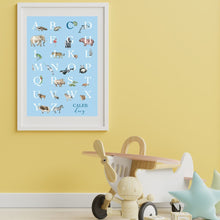 Load image into Gallery viewer, Personalised Kids' Animal Alphabet Poster in a soft blue colour. Featuring watercolour animals corresponding to the alphabet. Personalised with a child's full name. Features in kid's room with yellow wall.
