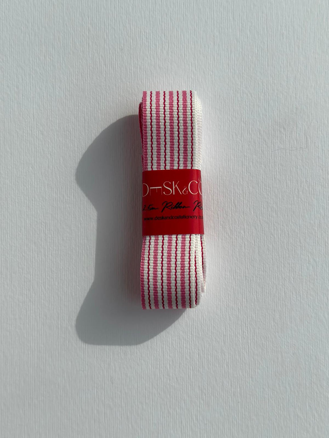 Premium Striped Grosgrain ribbon roll. Stripes include a dark pink, a light pink, and white stripes. Available in 2.5 metre rolls for stylish gift wrapping.