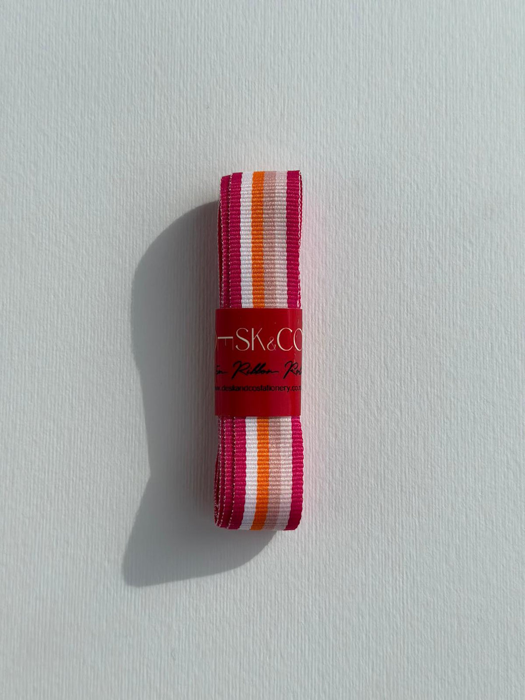 Premium Striped Grosgrain ribbon roll. Stripes include sunset colours - dark pink, light pinks, orange and white stripes. Available in 2.5 metre rolls for stylish gift wrapping.